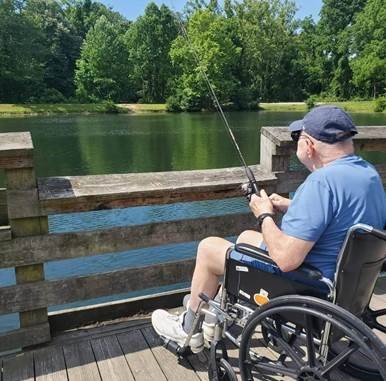 Senior male fishing on pier from wheelchair
